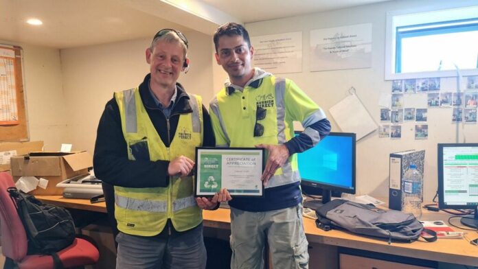 Jaspreetyear aniverary x jpg | Rubbish Direct Two Men in High visibility Vests Pose in an Office One Holding a Framed Certificate of Appreciation and Smiling